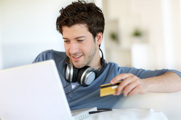 Teenage boy buying music online as authorized user