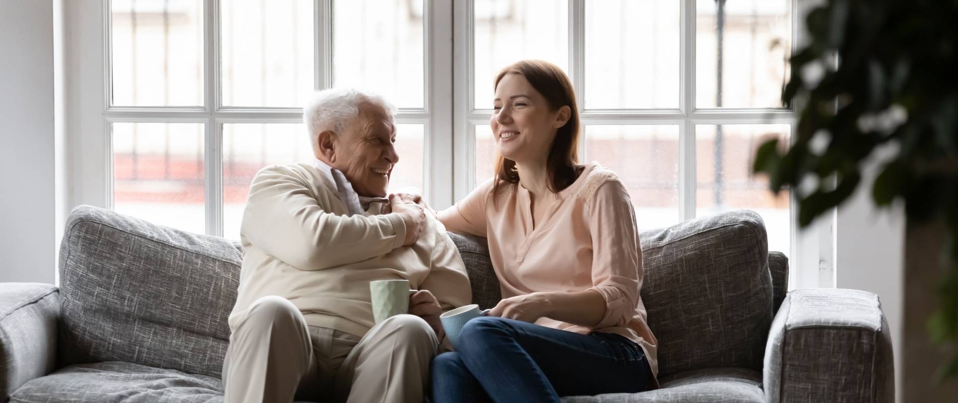 older man sitting next to younger woman on couch