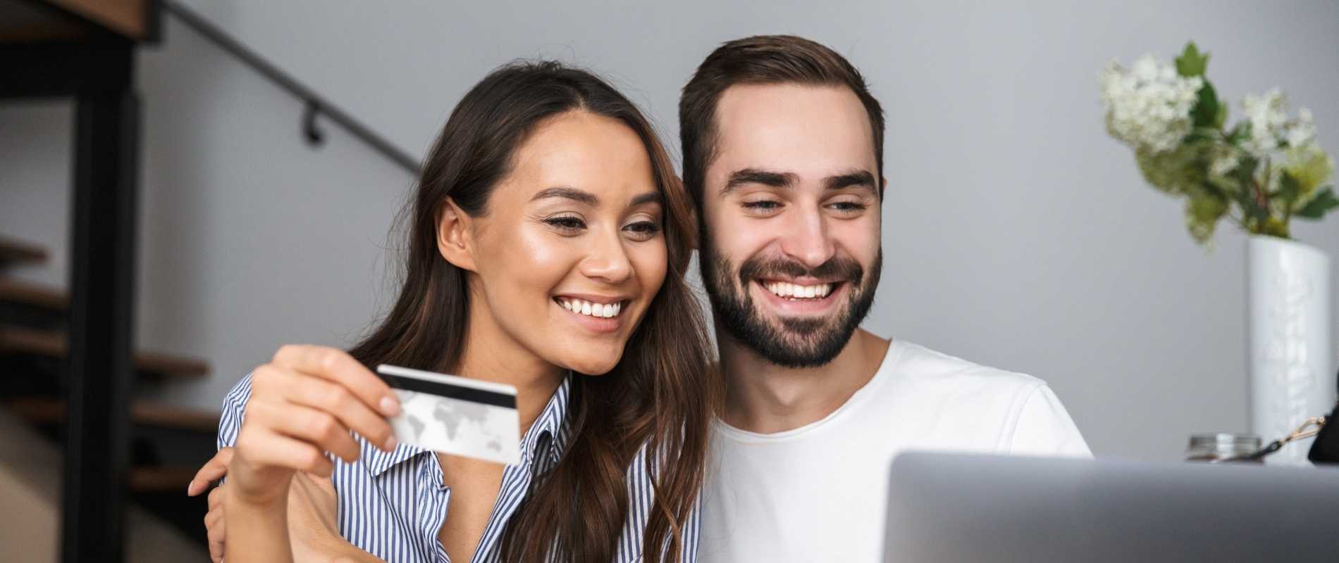 young couple at laptop with credit card