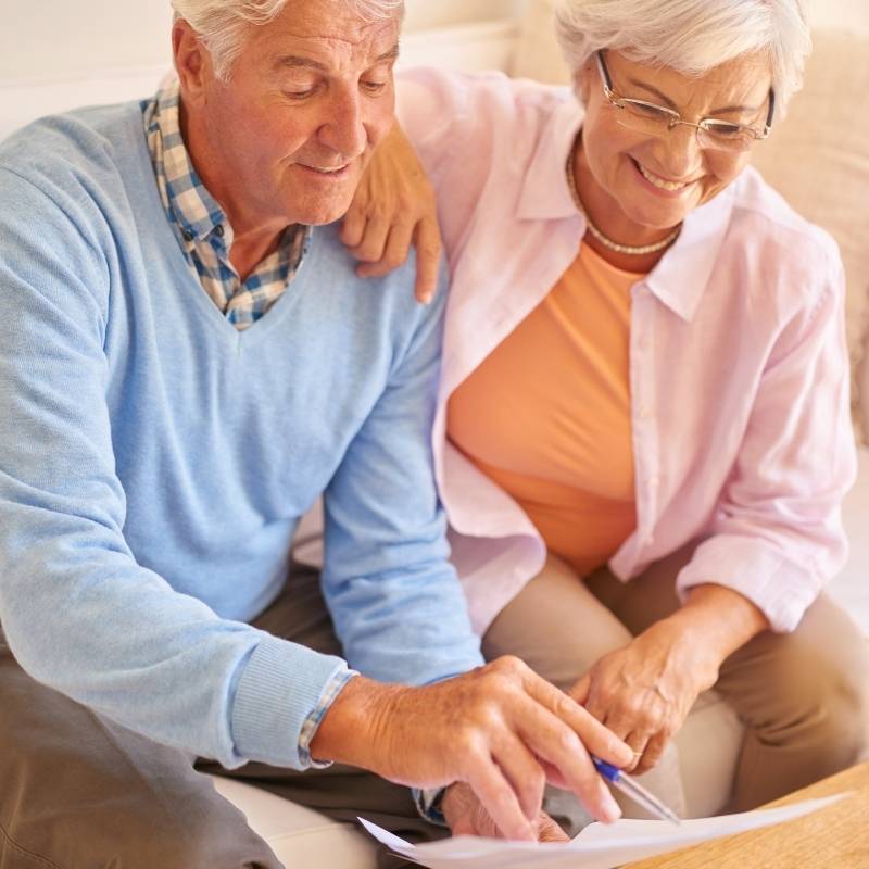 older couple on couch filling out income tax forms