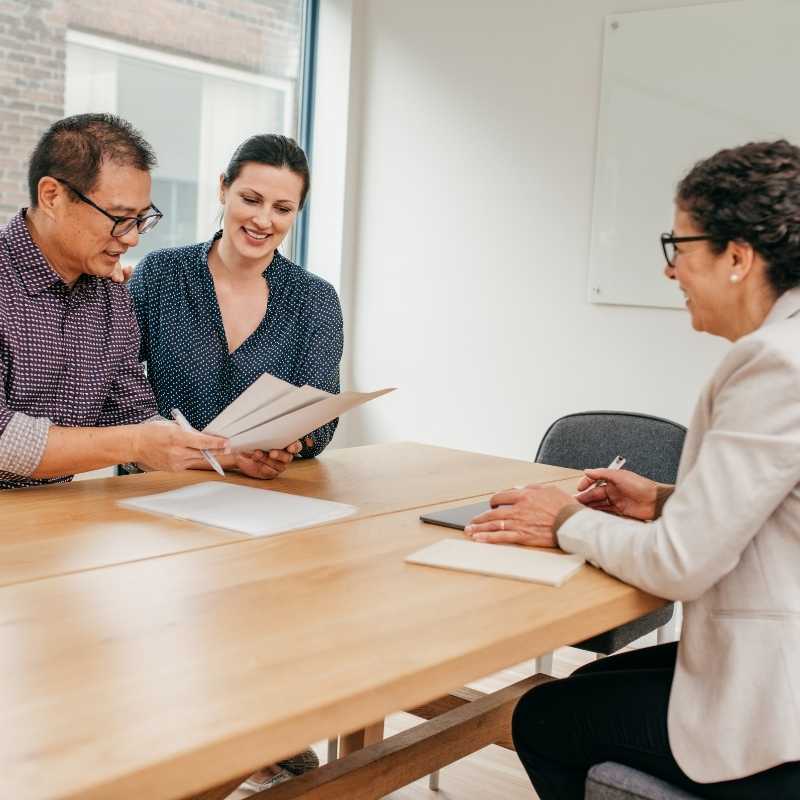 couple looking at investment property paperwork with expert