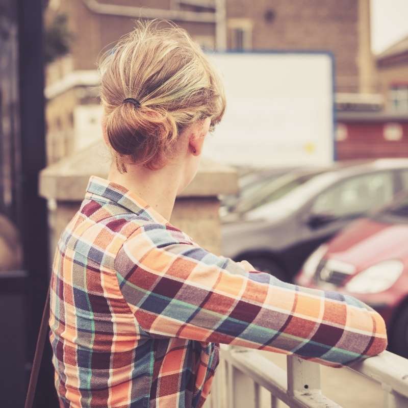 blond woman looking across parking lot