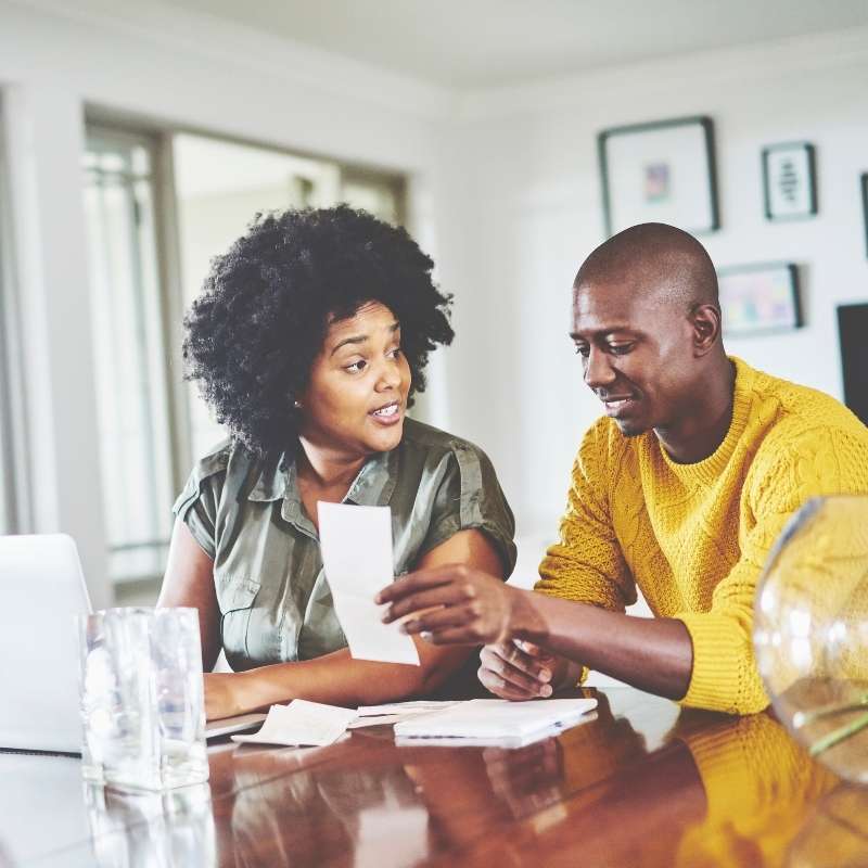 Black man and woman at kitchen table working on tax paperwork