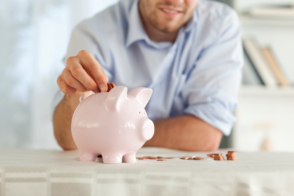 man saving money in piggy bank for sinking fund