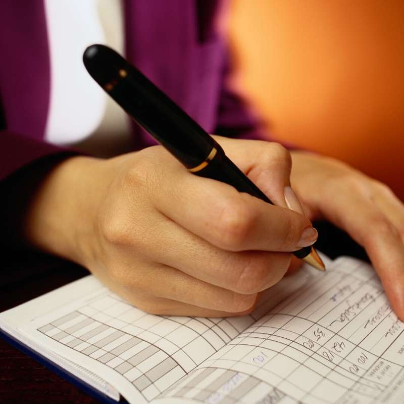 woman writing a check and saving money