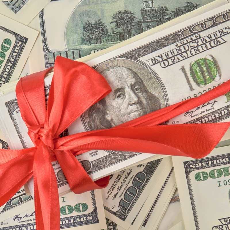 money wrapped in holiday ribbon