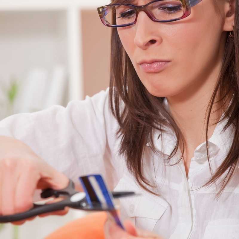 woman cutting expired credit card