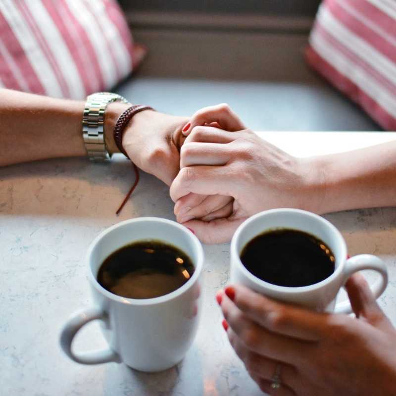 Couple holding hands over coffee planning retirement