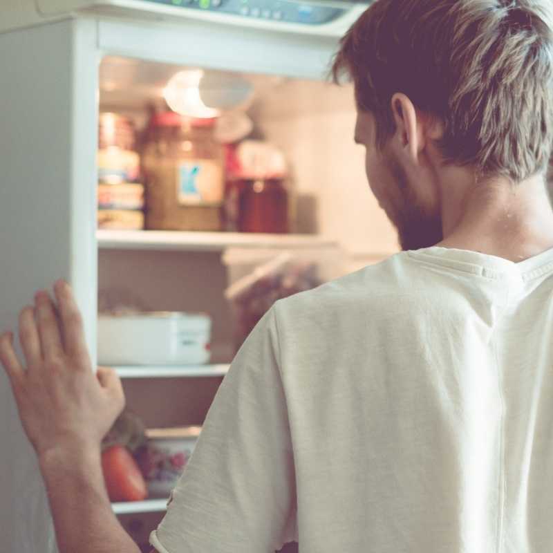 man looking in refrigerator