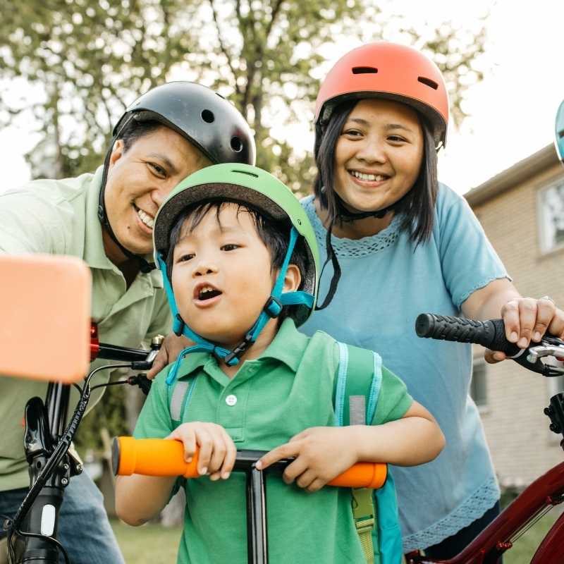 young boy on scooter taking selfie with parents