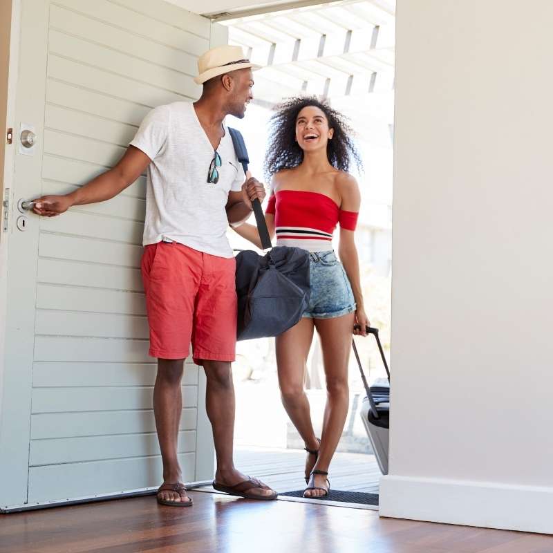 young couple entering front door of vacation rental property