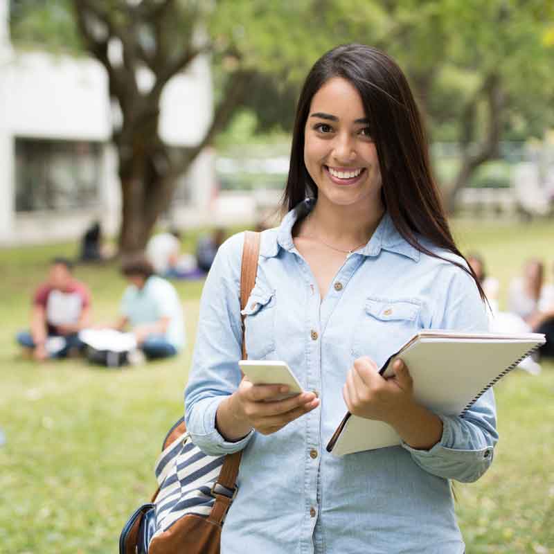 female college student holding cell phone to find atm machine