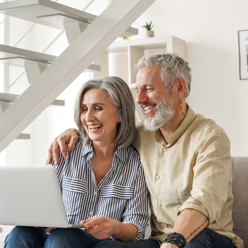 older woman and man looking at auto refinancing terms on laptop