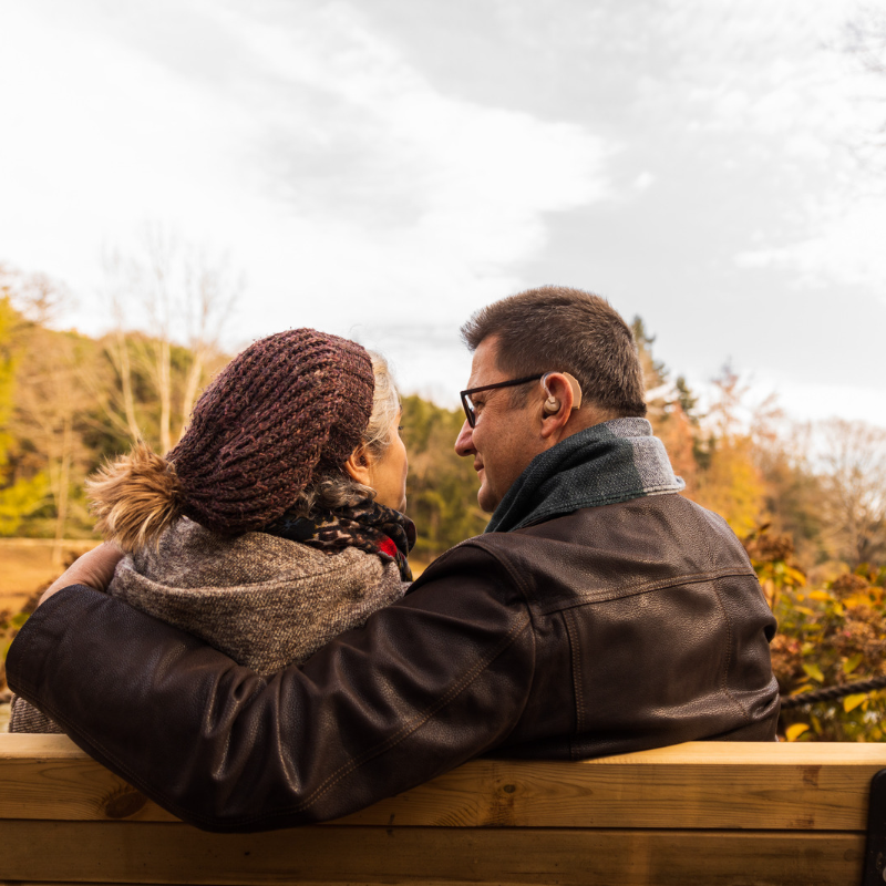 middle-aged white couple sitting on bench for a romantic date