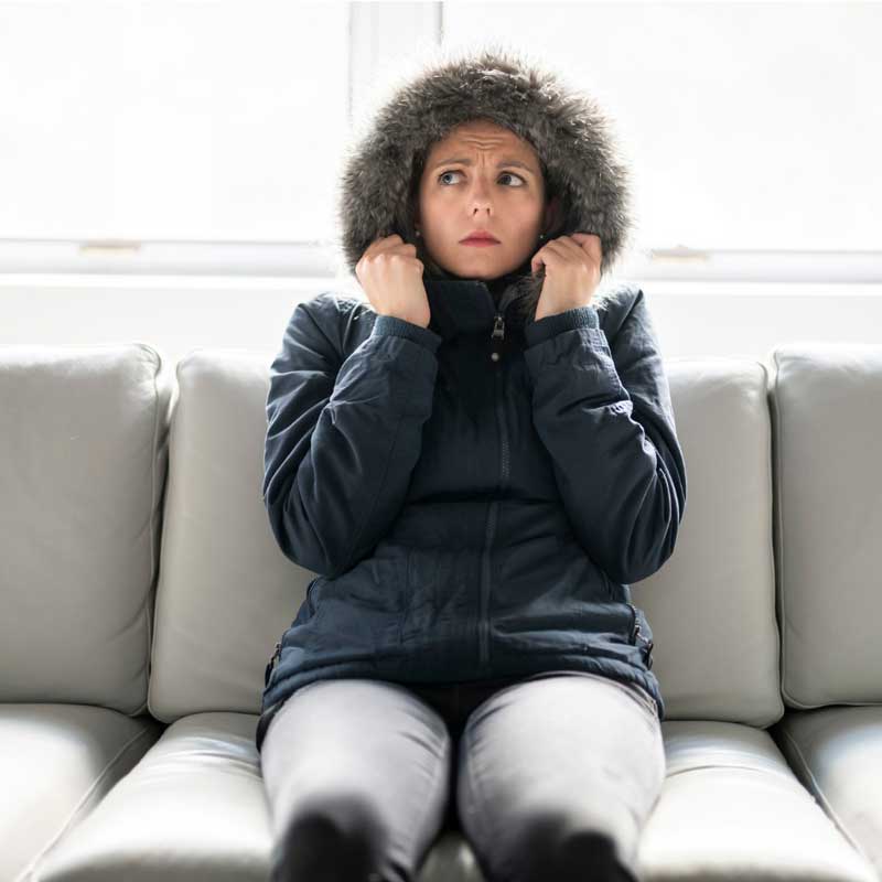 woman-have-cold-on-the-sofa-at-home-with-winter-coat-picture-id1070035724